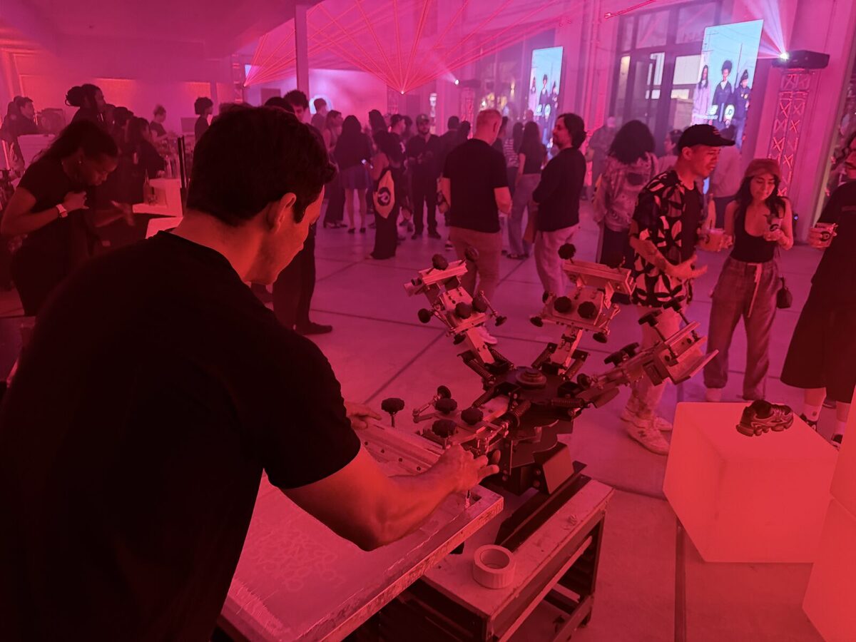 Guests gathered around a print station at a red-lit launch event